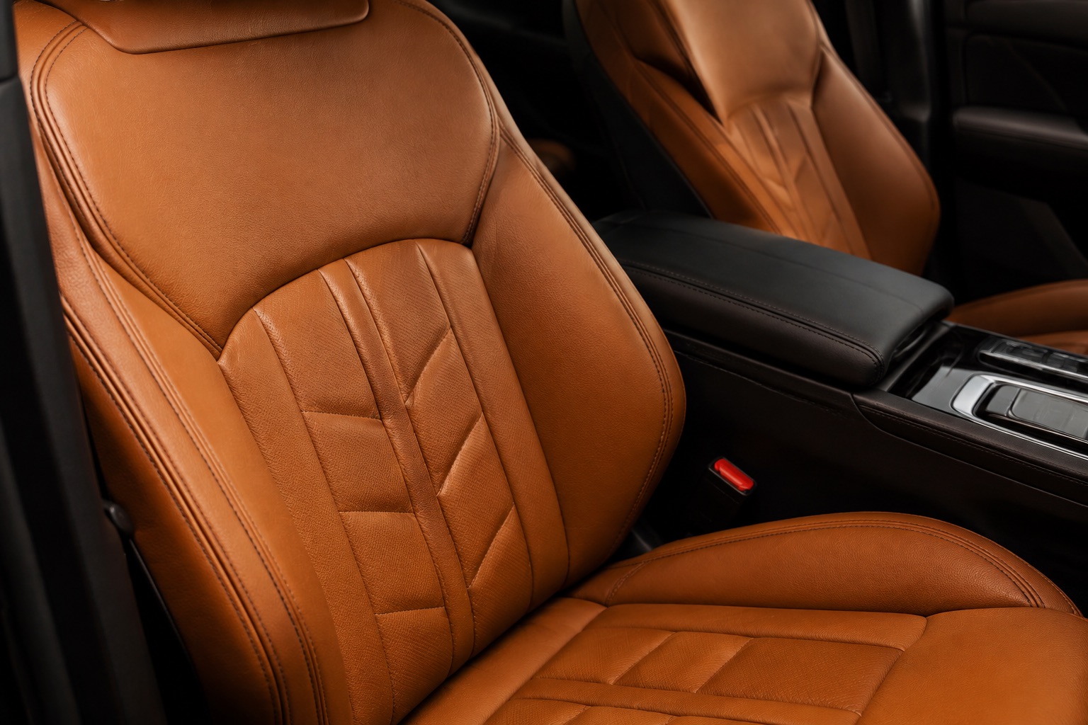 Detailed stitching and warm leather surfaces in a carefully cleaned car interior