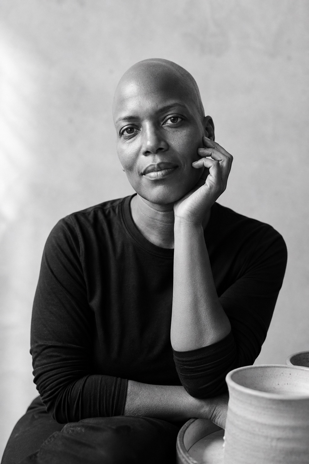 Black-and-white portrait of a ceramic artist resting her hand beside her cheek