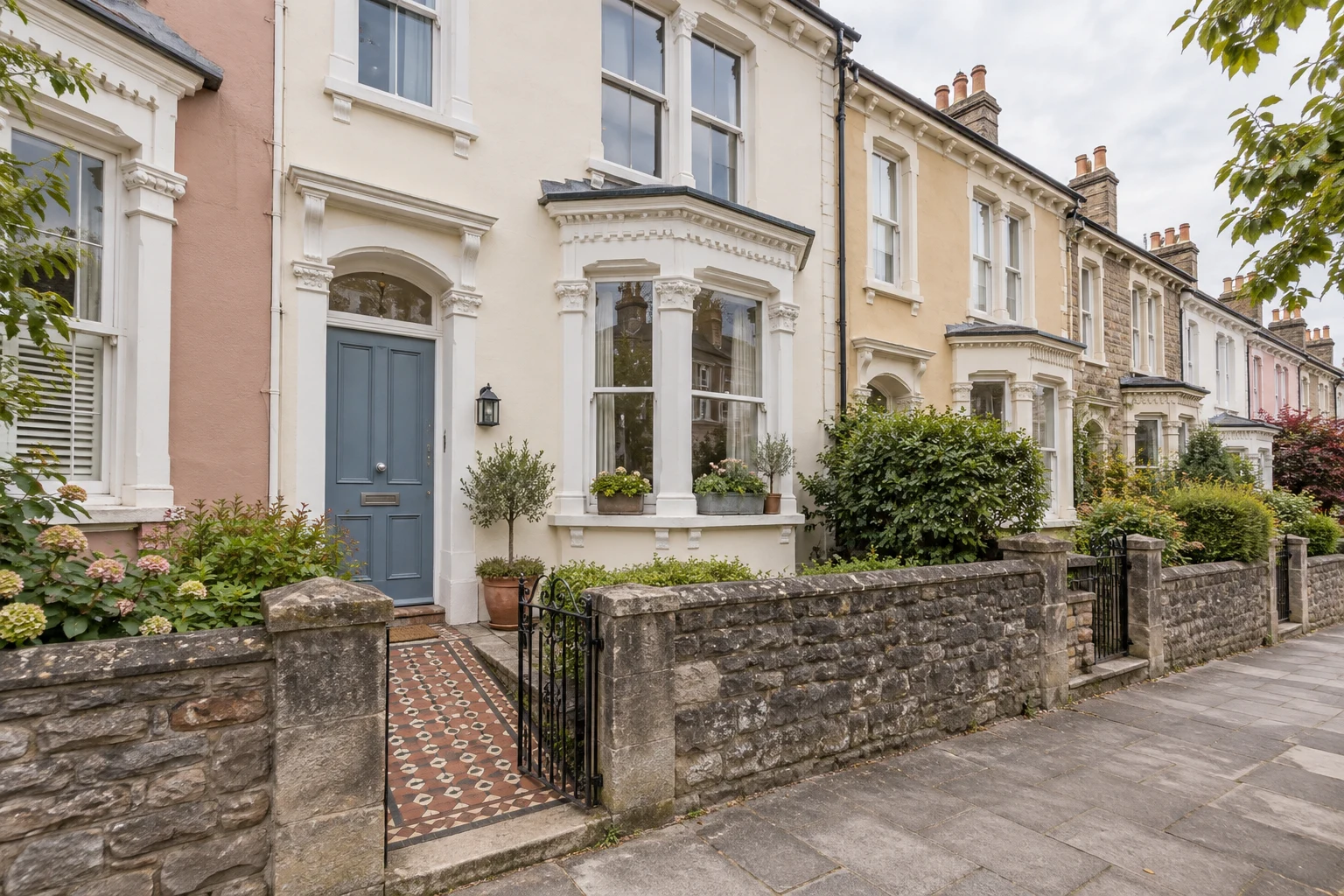 An imagined cream Victorian terrace in Southville with a dusty blue front door and a small planted front garden